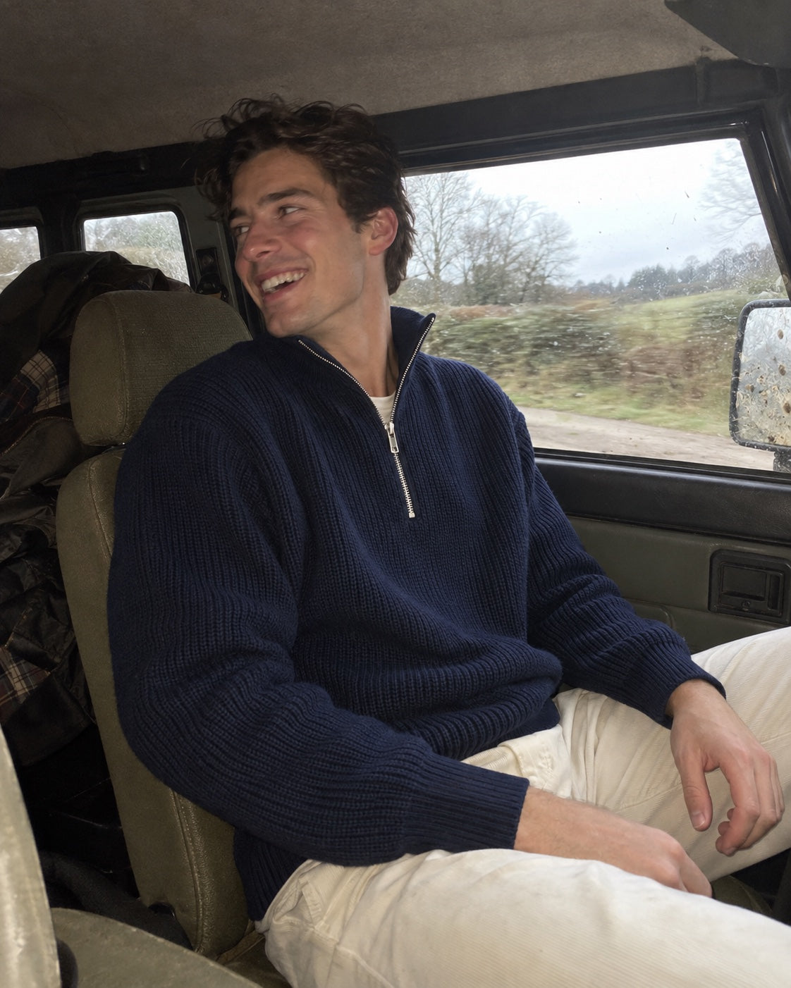 Customer wearing a navy half-zip in a country 4x4