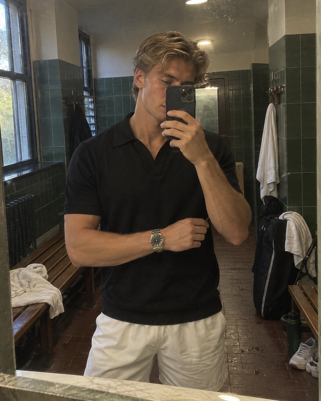 Customer wearing a dark polo in a tennis changing room